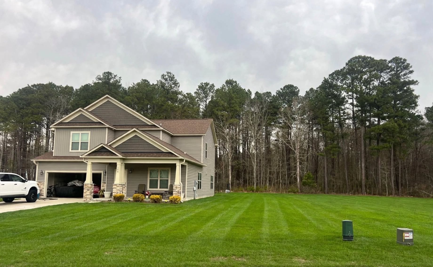 Freshly striped front lawn at a two-story home after a Johnson Hauling & Turf mow